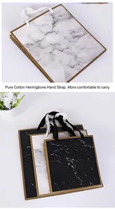 Close-up detail showing soft cotton herringbone handles on marble pattern gift bags