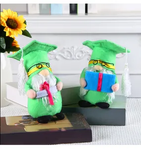 Primo piano di due gnomi di laurea verdi in peluche con tocco e diplomi arrotolati.