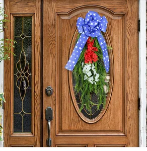 Corona de flores del Día de la Independencia con lazo azul estrellado en una puerta.