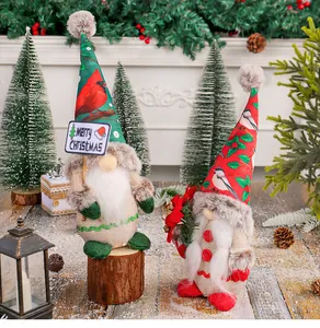 Vista detallada de gnomos navideños sin rostro con sombreros festivos y letrero de Navidad