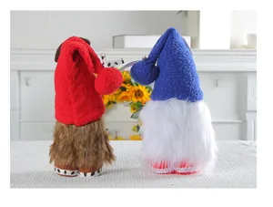 Due gnomi senza volto con cappelli lavorati a maglia rossi e blu in ambiente domestico