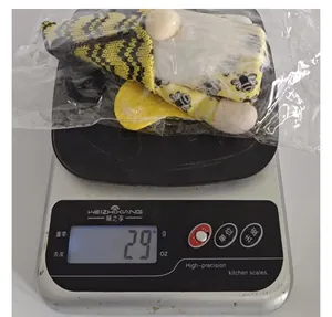 Détail d'un gnome bourdon en peluche pesant 29g sur une balance de cuisine pour référence.