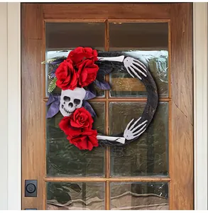 Détail d'une couronne d'Halloween avec des roses rouges et un crâne sur une porte