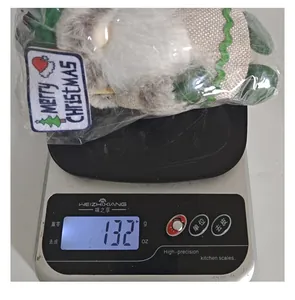 Detalle del peso de un muñeco de peluche de gnomo de Navidad en una báscula