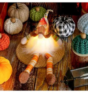 Detail of glowing autumn gnome with maple leaf hat and long striped legs for harvest decor