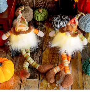 Detailed view of two light-up fall gnomes with maple leaf hats and long legs