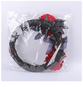 Couronne d'Halloween effrayante avec roses rouges et main de squelette sous emballage plastique