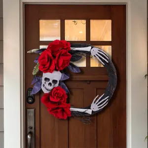Couronne d'Halloween avec roses rouges, crâne et mains de squelette sur une porte