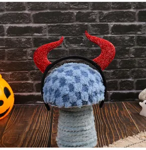 Serre-tête cornes de diable pailletées rouges Halloween sur un support de tête bleu