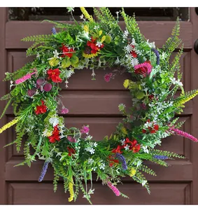 Vista dettagliata della ghirlanda di fiori selvatici artificiali su porta rustica.