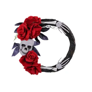 Couronne d'Halloween avec crânes réalistes roses rouges et mains de squelette décoratives
