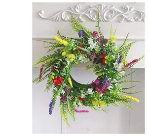 Dettaglio di una vivace ghirlanda di fiori selvatici artificiali con boccioli colorati su muro