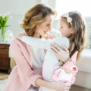 Mère et fille s'embrassant avec un adorable gnome rose en peluche pour la fête des mères.
