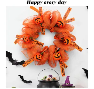 Nahaufnahme eines Halloween-Netzkranzes mit orangefarbenen Kürbissen und Bändern.