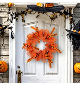 Halloween-Kürbiskranz an einer weißen Tür mit festlicher Dekoration.