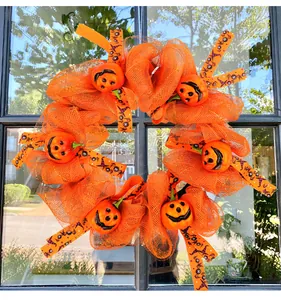 Auffälliger orangefarbener Halloween-Kranz mit süßen Kürbisgesichtern und Bändern.