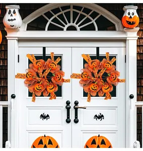 Halloween Kürbis-Kränze mit Netz und Bändern an einer weißen Haustür als Dekoration