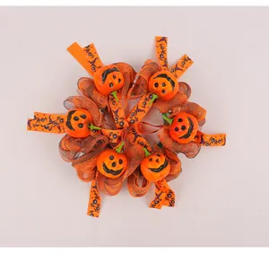 Detailansicht eines Halloween-Kranzes mit kleinen orangefarbenen Kürbissen.