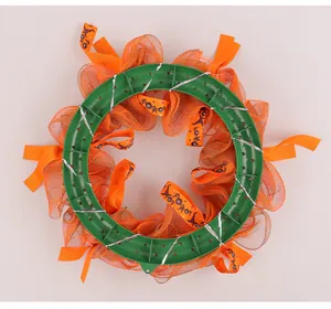 Detailansicht der grünen Kunststoffbasis eines Halloween-Türkrans mit orangem Netz