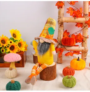 Detailansicht der herbstlichen Zwergpuppe auf einem Holzstumpf für Thanksgiving Deko