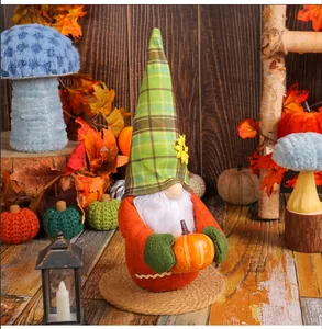 Detail view of a plush harvest festival gnome wearing a plaid hat and holding a pumpkin.