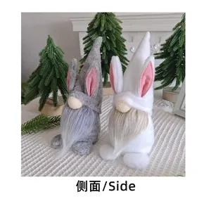 Vue latérale de deux jolies poupées gnomes de lapin de Pâques gris et blanc à barbe