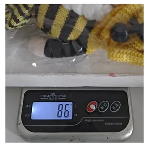 Gedetailleerde weergave van het gewicht van 86 gram van een gebreide bijen kabouter knuffel
