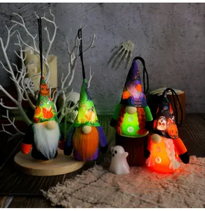 Close-up detail of four glowing Halloween gnome plush dolls with hanging loops