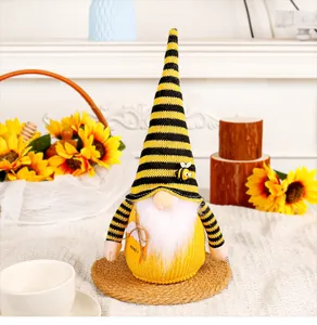 Adorable bumble bee gnome doll decoration with striped hat and Honey tag on a white table.
