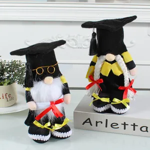Pair of handcrafted graduation gnomes wearing mortarboards and holding diplomas ornaments.