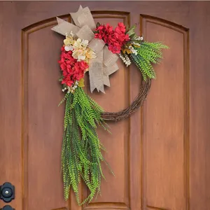 Rustic farmhouse artificial flower wreath with red blooms and burlap bow on wood door