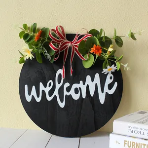 Detailed view of wooden round welcome door sign with eucalyptus and flowers decoration