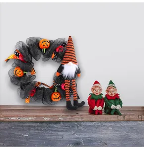 Gruseliger Halloween Gnom Kranz Dekoration mit Kürbissen auf einem rustikalen Regal