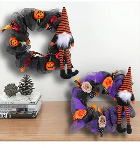 Detailansicht zweier Halloween-Kränze mit Netzstoff und langbeinigen Gnomen auf einem Schreibtisch.