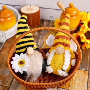 Paar gezellige gebreide bijen-gnomen met zonnebloemen en madeliefjes in een gevlochten mand