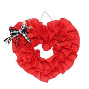 Detail of red heart-shaped burlap wreath with checkered bow for door decoration