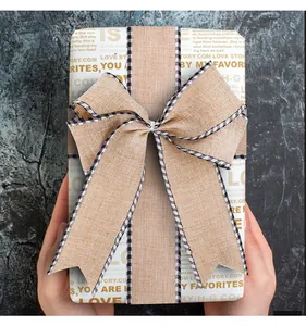 Macro detail of natural burlap bow with black and white checkered edges on gift box wrap