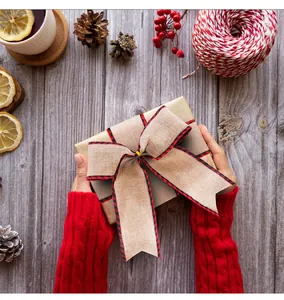 Close-up of a burlap plaid ribbon bow on a gift box in a festive setting