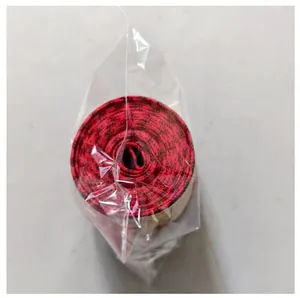 Close-up of red and black plaid burlap Christmas ribbon roll in plastic packaging