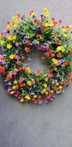 Vue détaillée d'une couronne de printemps artificielle colorée avec des fleurs mélangées