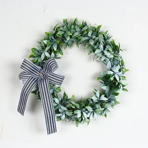 Detailed view of artificial eucalyptus wreath with flocked leaves and striped bow