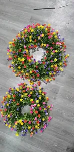 Vue de dessus de deux couronnes de fleurs artificielles colorées sur un sol gris
