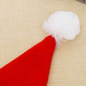 Close-up detail of a red brushed fabric Christmas hat with fluffy white pom-pom decoration
