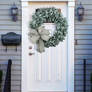 Detailed view of a green faux lamb's ear leaf wreath with striped bow on a door