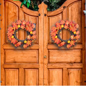 Harvest Festival autumn wreath with maple leaves and pumpkins on a rustic wooden door