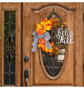 Close-up of fall wreath with maple leaves and Hello Fall sign on a wooden door.