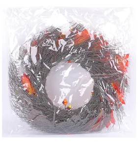 Detail view of harvest maple leaf wreath wrapped in protective clear plastic bag