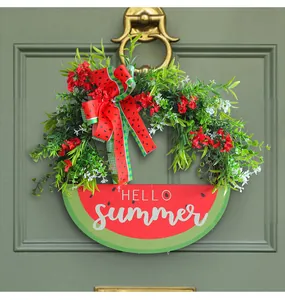 Detail view of artificial watermelon wreath with HELLO summer sign on a green door