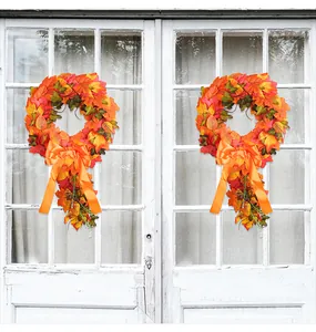 Autumn maple leaf wreath with a large orange bow hanging on a vintage white door