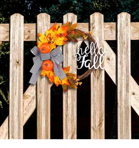 Fall wreath decoration with maple leaves, pumpkins, and a Hello Fall sign on a wooden fence.